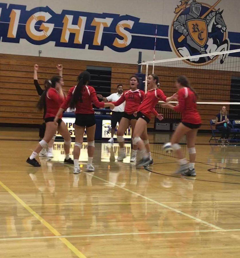 Varsity players come together and cheer after earning a point