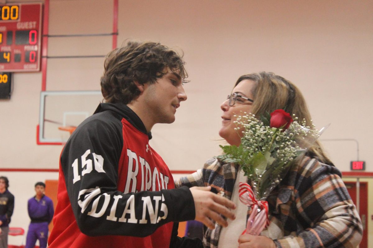 Senior+Josh+Waltrip+gives+flowers+to+his+mom.+