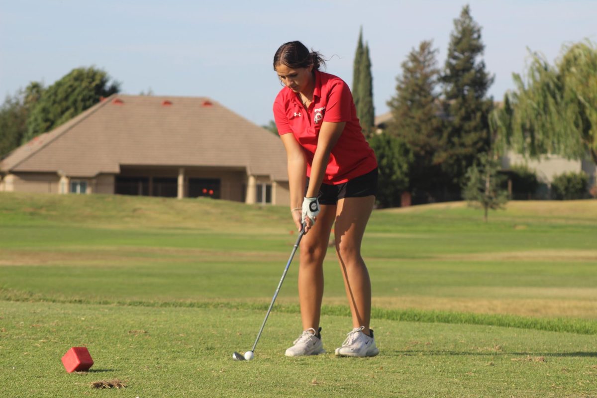 Freshman Eve Toledo preparing to take a tee shot